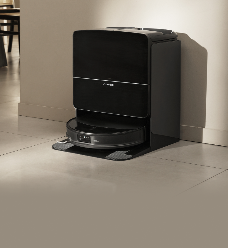 Black Roborock Saros 10R robot vacuum docked in a black base station on a light-colored floor